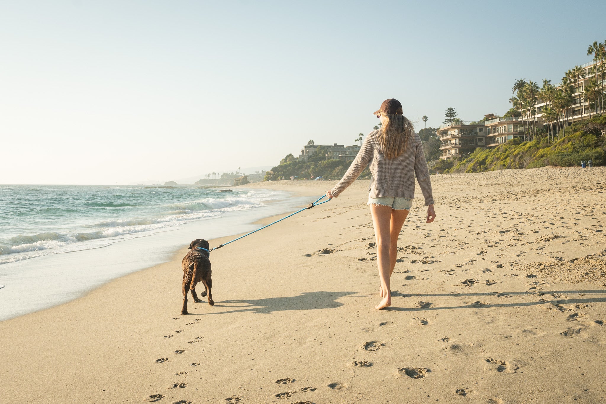 Rope Dog Leash and Rope Dog Collar Ocean Beach, a woman walks with her dog down a beach in laguna beach with a rope dog leash and a rope dog collar